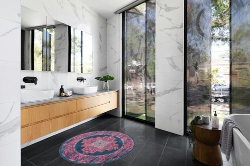 HomeRoots 4' Blue Round Power Loom Area Rug in Modern Black Tiled bathroom