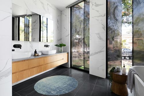 HomeRoots 4' Ivory and Blue Round Abstract Power Loom Area Rug in Modern Black Tiled bathroom