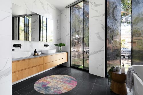 HomeRoots 4' Blue and Pink Round Abstract Power Loom Area Rug in Modern Black Tiled bathroom