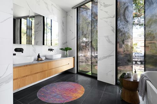 HomeRoots 4' Blue and Pink Round Abstract Power Loom Area Rug in Modern Black Tiled bathroom