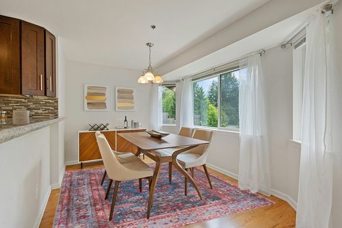 Safavieh Tucson Collection Area Rug - 8' Round, Rust & Blue, Traditional Persian Design, Non-Shedding Machine Washable & Slip Resistant Ideal for High Traffic Areas in Living Room, Bedroom (TSN153P) in Modern White Dining Room with Wooden Accents