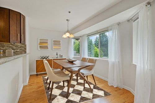 nuLOOM Meline Checkered Fringe Area Rug, 5x8, Beige in Modern White Dining Room with Wooden Accents