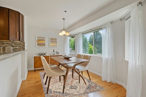 Loloi II Sorrento Collection SOR-05 Ivory/Fiesta 5'-3" x 7'-6" Area Rug in Modern White Dining Room with Wooden Accents