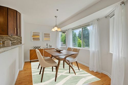 SAFAVIEH Adirondack Collection Area Rug - 6' x 9', Sage & Cream, Modern Wave Distressed Design, Non-Shedding & Easy Care, Ideal for High Traffic Areas in Living Room, Bedroom (ADR125X) in Modern White Dining Room with Wooden Accents