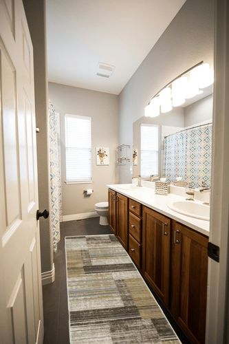 HomeRoots 8' Beige Charcoal Brown Grey Tan Gold and Blue Geometric Power Loom Runner Rug with Fringe in Wooden and Grey Bathroom