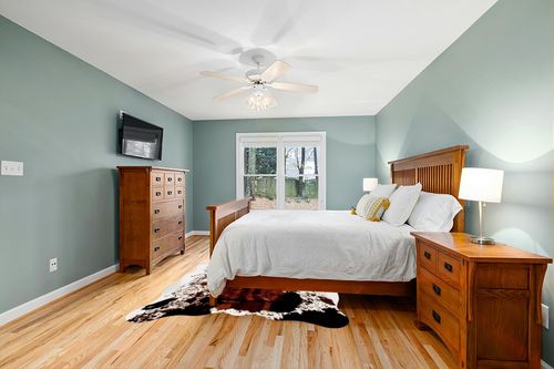 CONBEN Oversized Faux Cowhide Rug (6.3ft x 8.3ft) - Non-Slip Backing, Cow Print Decor - Farmhouse, Western Floor Rugs for Living Room, Bedroom, Dining Area or Office in Teal and Orange Wood Bedroom