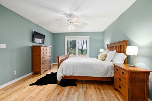 Faux Fur Cowhide Rugs (5 * 7 ft), Machine Washable Cow Print Area Carpet Black Color with Non-Slip Suede Backing, Durable & No Shedding in Teal and Orange Wood Bedroom