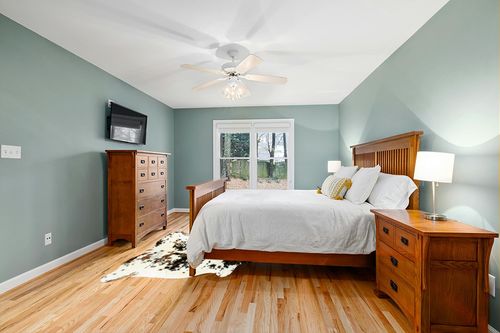 HIDES BAZAAR Light Tricolor Cowhide Rug, Premium Quality Genuine Leather Cow Hide, White, Brown and Black Color Mix Area Rug (5x7 ft) in Teal and Orange Wood Bedroom