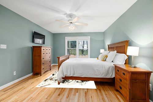 HIDES BAZAAR Light Tricolor Cowhide Rug, Premium Quality Genuine Leather Cow Hide, White, Brown and Black Color Mix Area Rug (6x7 ft) in Teal and Orange Wood Bedroom