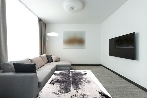 nuLOOM Halina Faux Cowhide Area Rug, 5' 9" x 7' 7", Black in Modern Living Room with Grey Couch