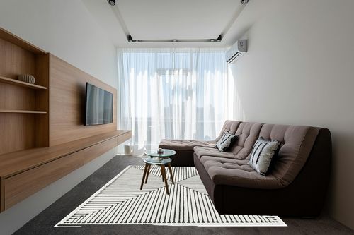 RUGGABLE x Jonathan Adler Washable Rug - Perfect Modern Area Rug for Living Room Bedroom Kitchen - Child Friendly - Stain & Water Resistant - Inkdrop Black & Ivory White 8'x10' (Standard Pad) in Grey Living Room with Brown Couch