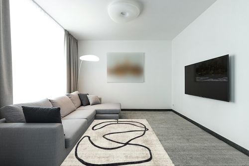 nuLOOM Hayley Modern Abstract Fringe Beige 5 ft. x 8 ft. Area Rug in Modern Living Room with Grey Couch