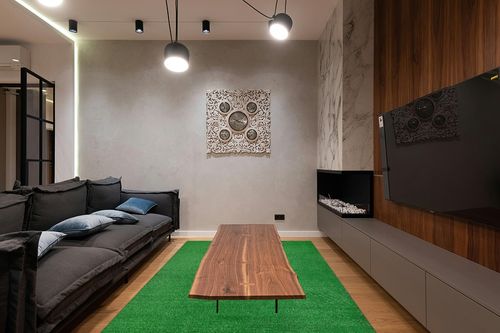 Garland Rug Artificial Grass 6 ft. x 9 ft. Large Indoor/Outdoor Area Rug Green in Dark Wood Living Room with Black Couch