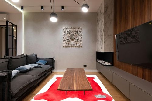 Appaloosa Cowhides Color Dyed Collection (Rusty Red) in Dark Wood Living Room with Black Couch