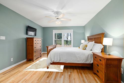 Signature Design by Ashley Jaxith Farmhouse 5 x 7 Medium Pile Cowhide Rug, Ivory & Tan in Teal and Orange Wood Bedroom