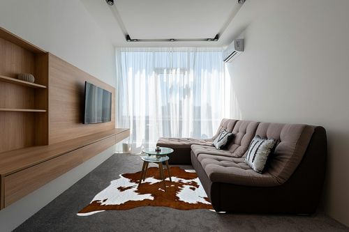 rugoo Faux Cowhide Rug 8.3 ft x 6.2 ft Cow Print Rug Faux Animal Skin Rug for Living Room Bedroom Nursery, White and Brown in Grey Living Room with Brown Couch